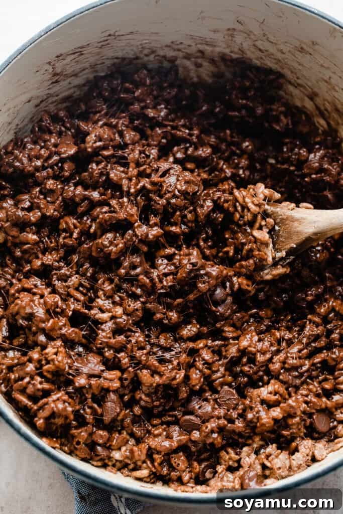 A pot filled with the chocolate cereal and marshmallow mixture, ready to be pressed into a pan.