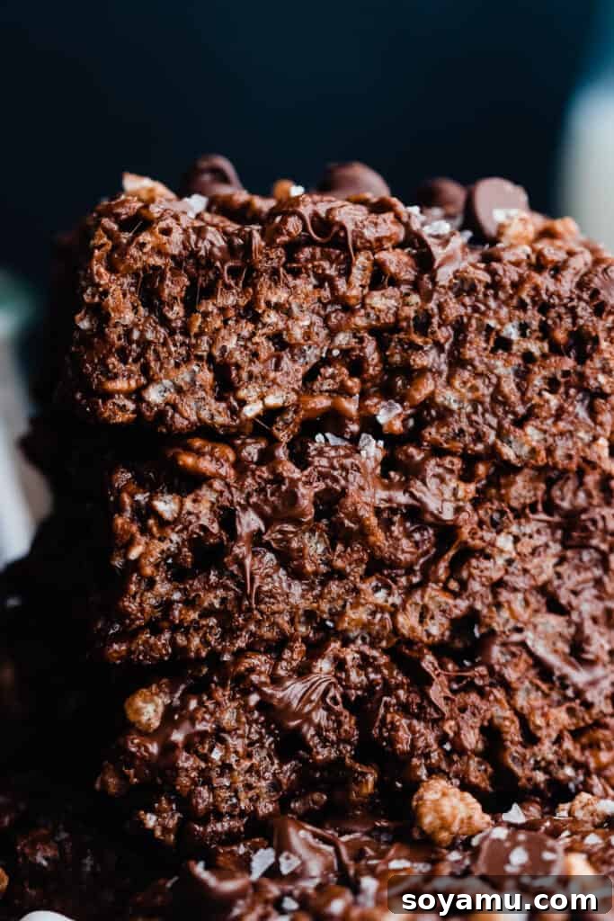 A close-up shot of a stack of four chewy brown butter chocolate rice krispie treats.