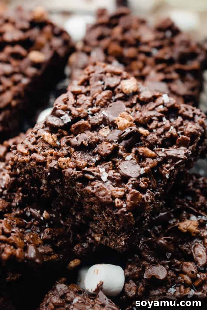 A close-up detail shot of a single brown butter chocolate rice krispie square, highlighting its texture.