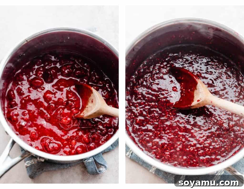 A pot of raspberry sauce simmering on the stove, showing berries breaking down.