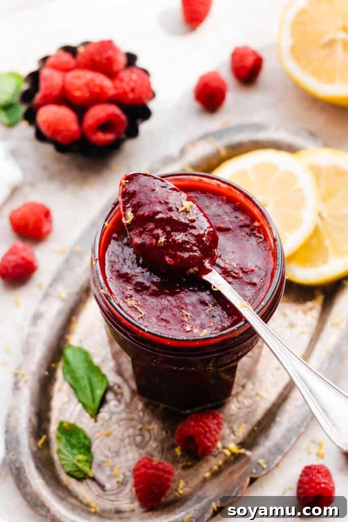 A charming glass jar filled with luscious raspberry coulis, ready for serving.