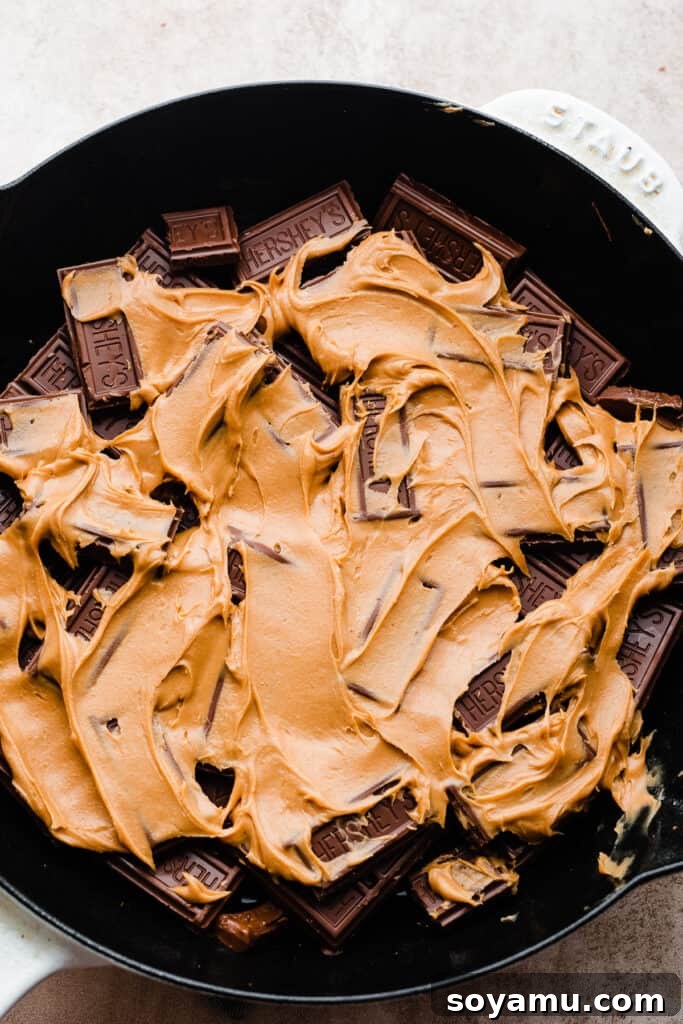 Simple 15 Minute Skillet Smores Dip 5 A smooth layer of creamy peanut butter is artfully dolloped and lightly spread over the rich melted chocolate in the skillet, adding a delectable nutty dimension to the s'mores dip.
