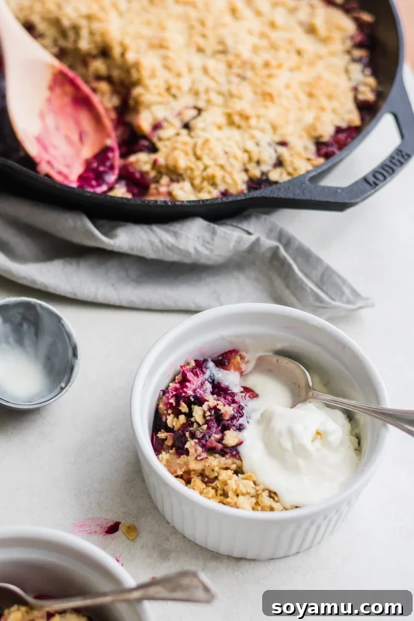 Close-up of the bubbling, golden-brown oat topping on the Summer Glory Skillet Crumble, fresh out of the oven.
