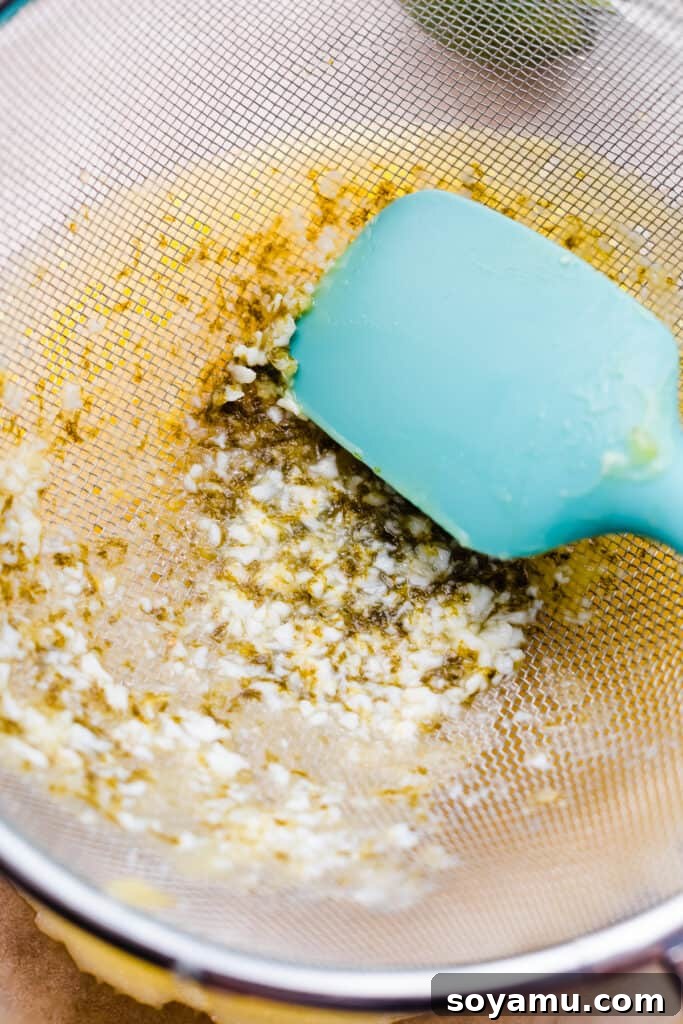 Zesty Homemade Lime Curd 7 Curd being pushed through a strainer.