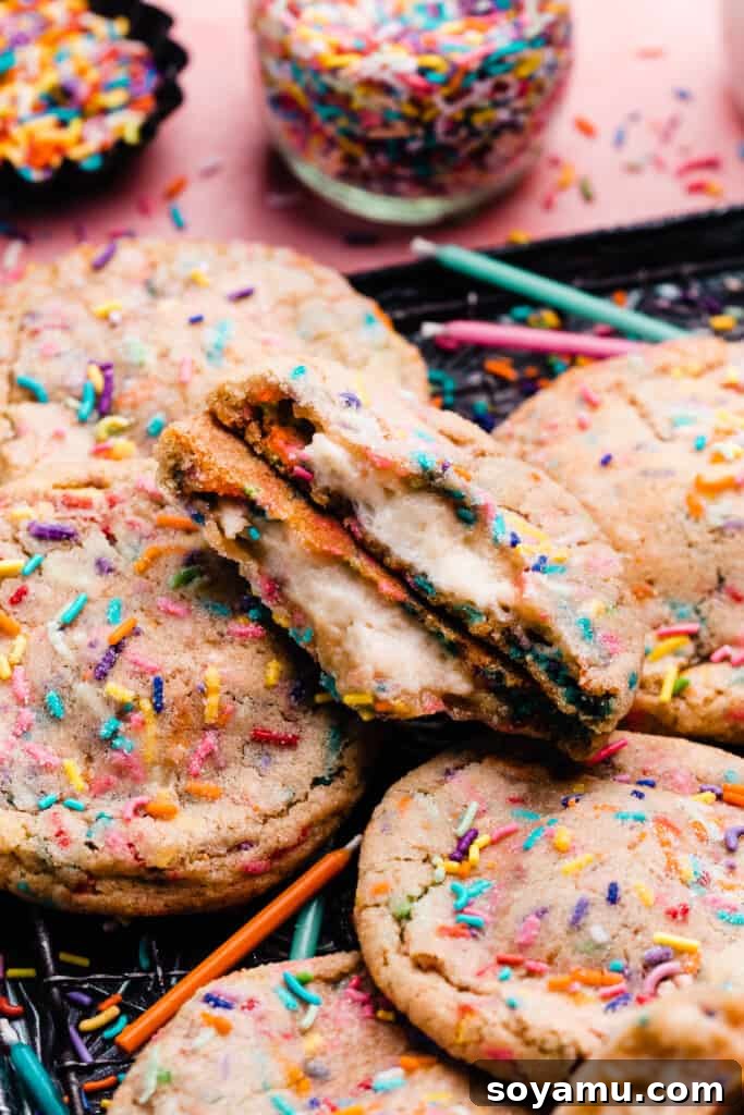 Irresistible Funfetti Cookies with a Cake Batter Cheesecake Surprise 12 A generous pile of freshly baked funfetti cookies adorned with colorful sprinkles, resting invitingly on a baking tray, ready to be enjoyed.