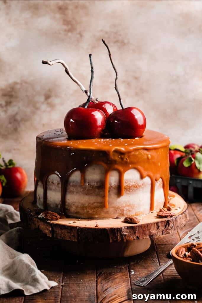 Autumn Apple Caramel Delight 11 The fully assembled Caramel Apple Cake, adorned with a salted caramel drip and homemade candy apples, standing tall and inviting.