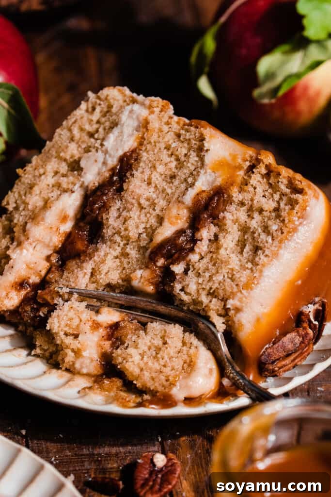 Autumn Apple Caramel Delight 10 A close-up photograph of a perfect slice of Caramel Apple Cake, showcasing its multiple layers, apple filling, and decadent frosting.