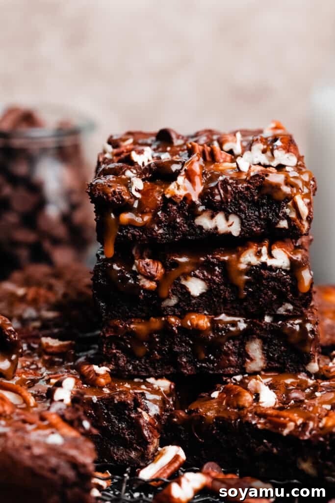Irresistible Turtle Brownies 8 A stack of turtle brownies with caramel dripping down.