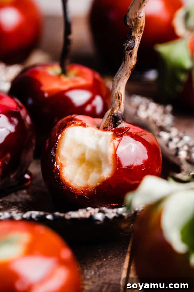 Vibrant red toffee apples arranged elegantly on a vintage tray, each pierced with a sturdy wooden skewer, ready to be enjoyed.