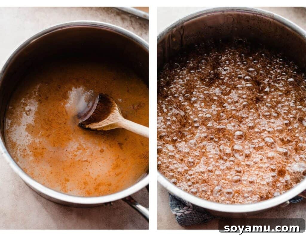A medium pot containing a bubbling, vibrant red sugar syrup, actively cooking on a stovetop with a candy thermometer inserted.