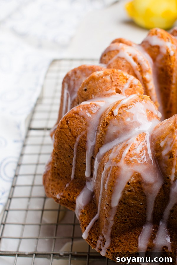 Beautifully decorated Lemon Poppy Seed Bundt Cake on a white stand