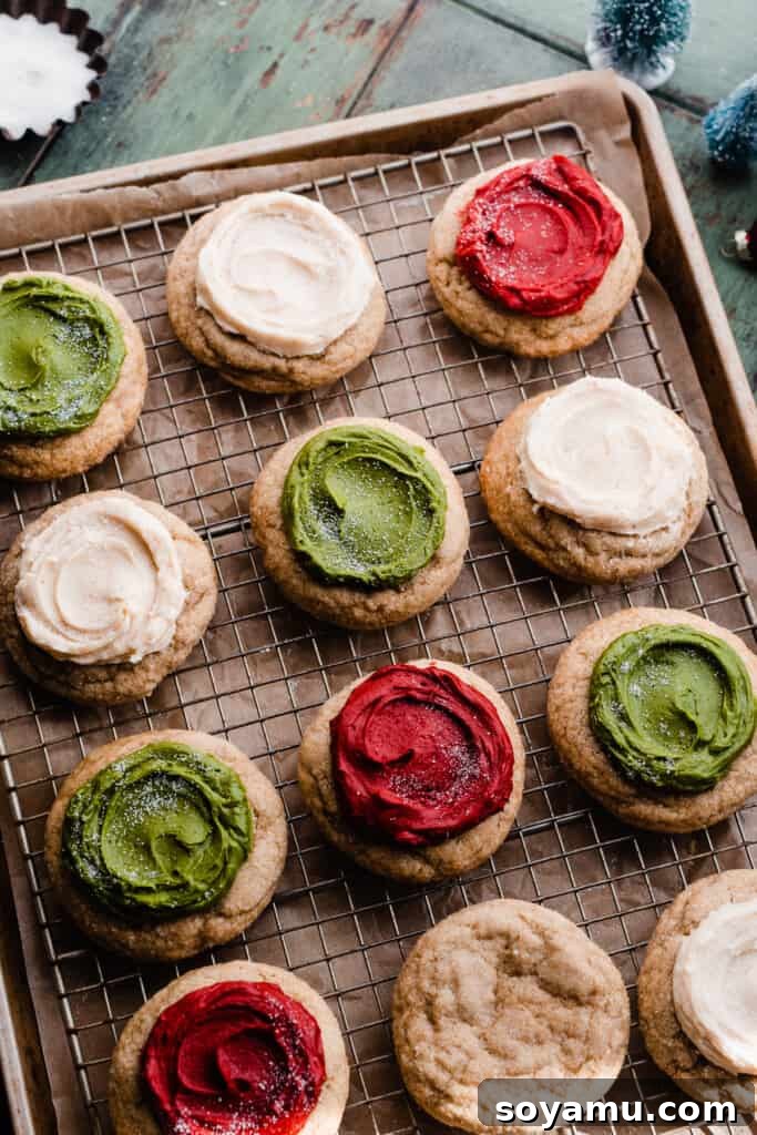 Ultra Chewy Frosted Sour Cream Cookies 11 A cooling rack laden with beautifully frosted sour cream cookies, adorned with festive colors and a sprinkle of sanding sugar.