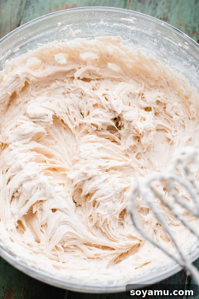 Ultra Chewy Frosted Sour Cream Cookies 9 A bowl of rich brown butter cream cheese frosting, smooth and ready for decorating, showcasing its creamy texture.
