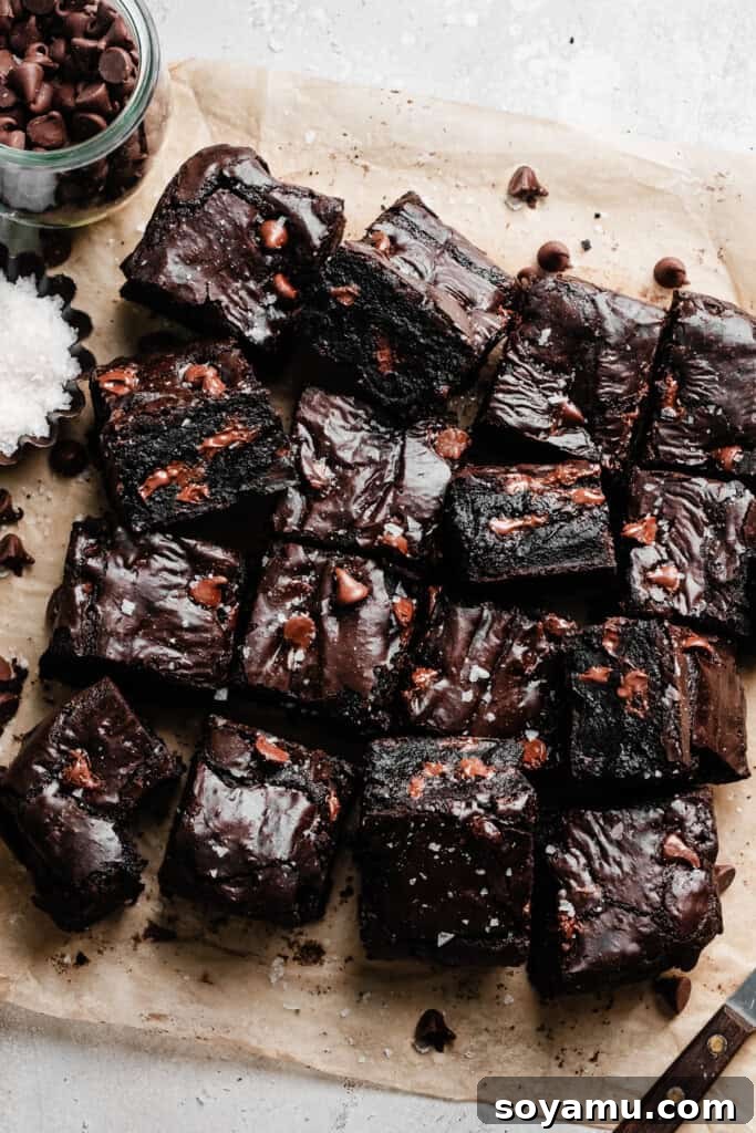 Ultra Fudgy Gluten Free Brownies 3 The sliced gluten-free brownies cooling on a piece of parchment paper, showcasing their even cut and enticing texture.