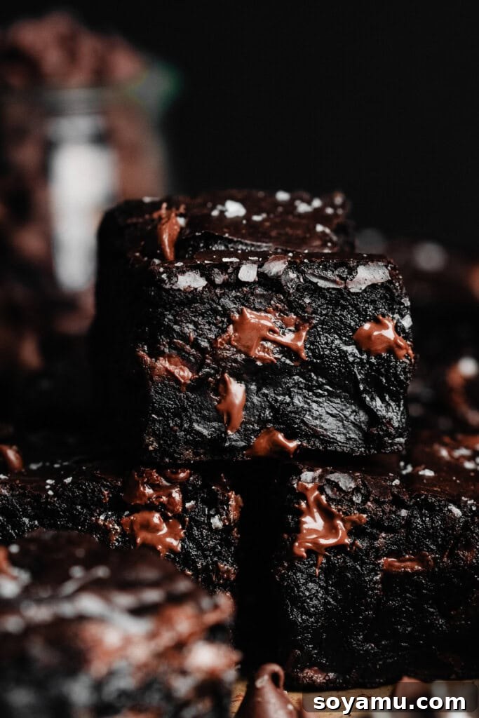 Fudgy Gluten-Free Brownies - The most perfect, rich, deeply flavored brownies with a fudgy center and crackly lid - and they happen to be GLUTEN FREE! All you need are basic pantry staples and some almond flour to make these little bites of heaven a reality! #fudgybrownies #glutenfreedesserts #glutenfreebrownies #brownierecipe #easybrownies #chocolaterecipes #easydesserts #bluebowlrecipes | bluebowlrecipes.com A close-up on a stack of perfectly cut fudgy gluten-free brownies, showcasing their appealing appearance.