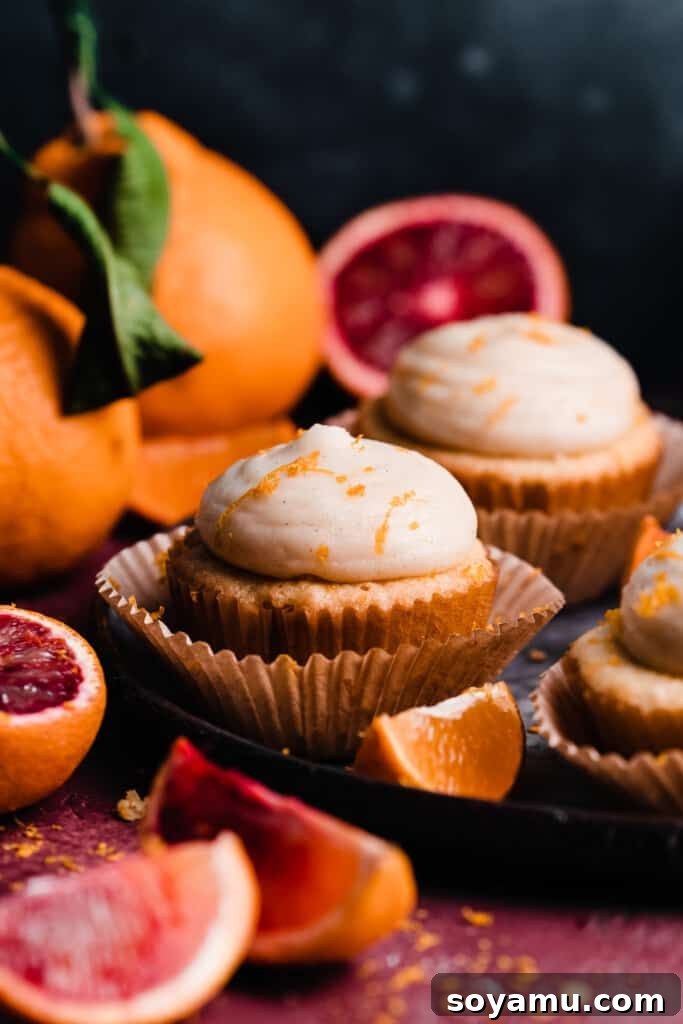 A charming plate holding several perfectly frosted orange cupcakes, adorned with delicate orange zest, ready to be served.