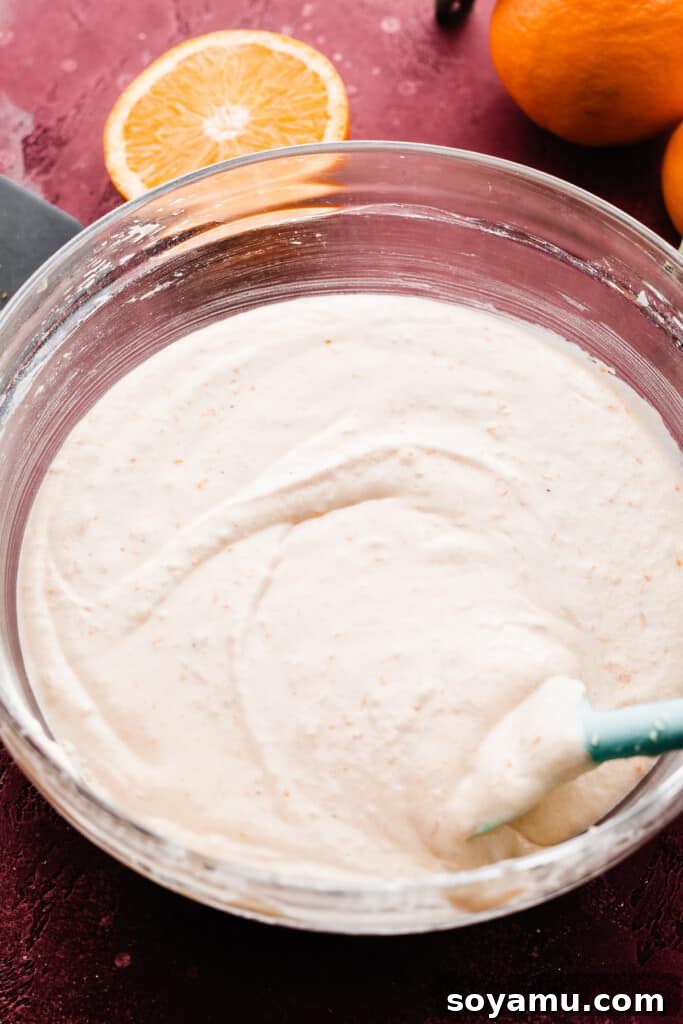 A large mixing bowl showcasing the fully prepared cupcake batter, appearing smooth, homogenous, and ready for baking.