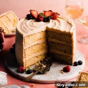 The sliced open 8-inch cake frosted in brown butter frosting and topped with fresh berries.