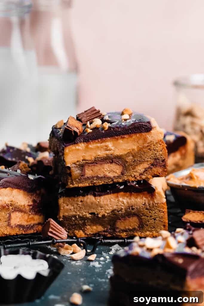 Peanut Butter Overload Blondies with Chocolate Ganache 3 A stack of two beautifully layered peanut butter blondies with milk bottles behind them, ready to be enjoyed.
