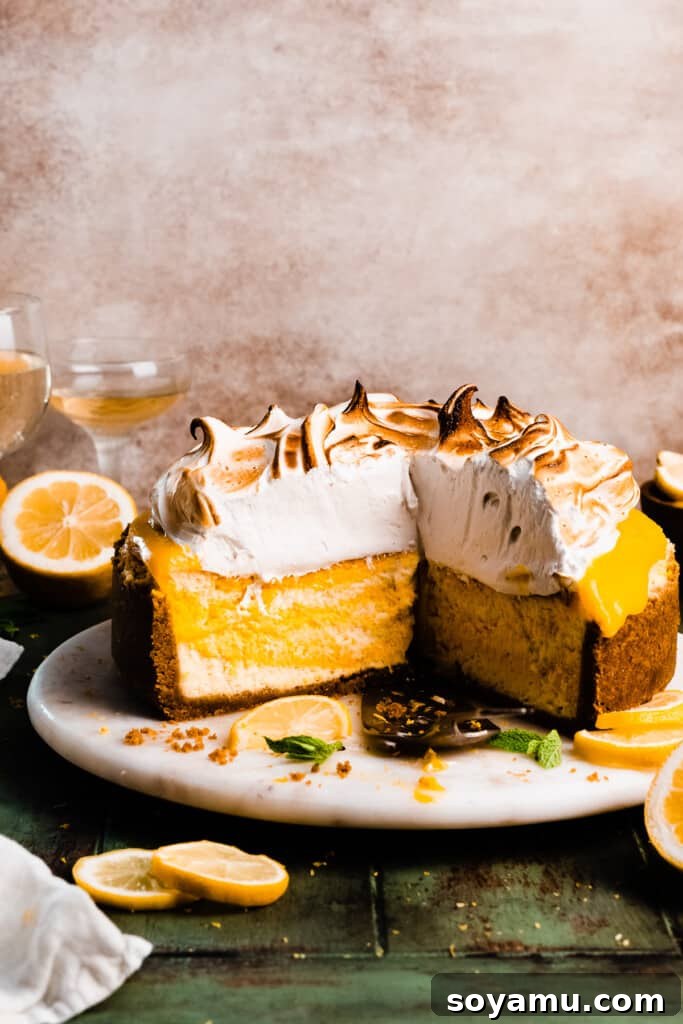 A beautifully sliced lemon meringue cheesecake on a pristine marble plate, showcasing its distinct layers: golden graham cracker crust, creamy pale yellow cheesecake, a vibrant lemon curd layer, and a sky-high cloud of toasted meringue.