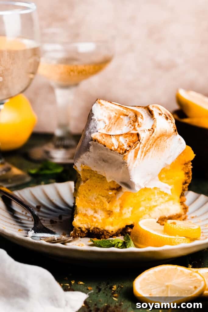 A delectable slice of lemon meringue cheesecake with a few bites already taken, revealing the thick, creamy lemon layers and the inviting graham cracker crust, all topped with fluffy, toasted meringue.