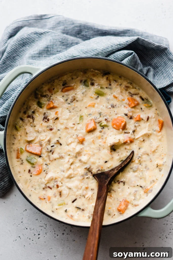 Soulful Chicken Wild Rice Soup 6 A large pot of the creamy chicken wild rice soup, simmering gently on the stovetop, its rich aroma filling the kitchen.