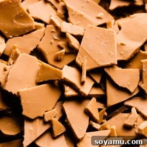 A close-up of chunks of caramelized white chocolate. The pieces are a deep caramely color.