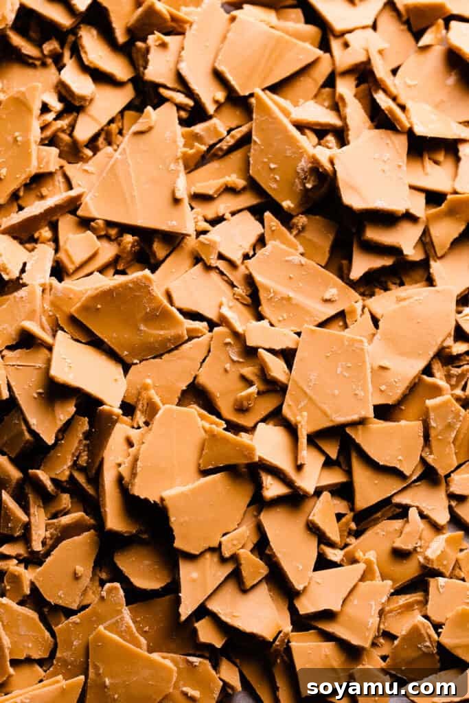 Unlocking the Flavor of Caramelized White Chocolate 9 Close-up of hardened, deeply golden-brown caramelized white chocolate shards, emphasizing its rich color and inviting texture.