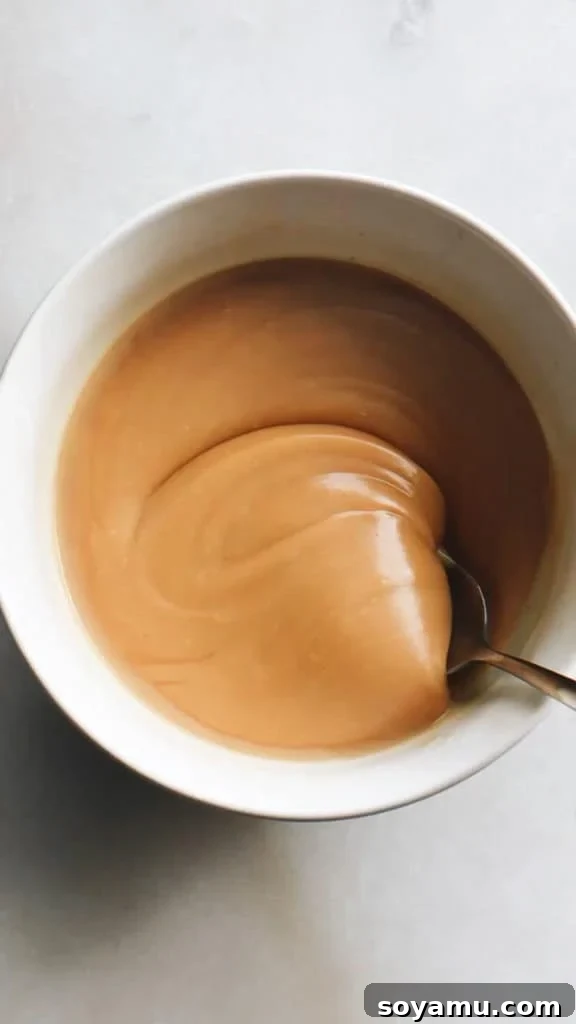 Unlocking the Flavor of Caramelized White Chocolate 10 A bowl of creamy, golden caramelized white chocolate ganache, highlighting its use in creating luxurious dessert fillings and toppings.