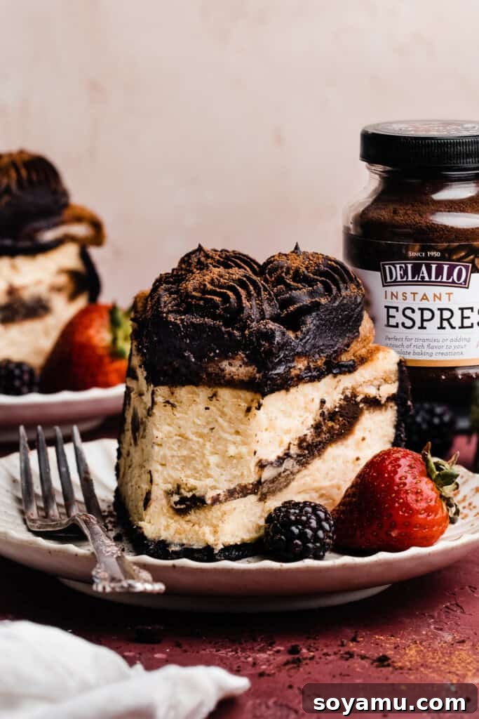 Decadent Mocha Tiramisu Cheesecake 3 A tantalizing slice of tiramisu cheesecake on a plate, with a small portion already enjoyed, revealing the creamy layers and espresso-soaked ladyfingers.