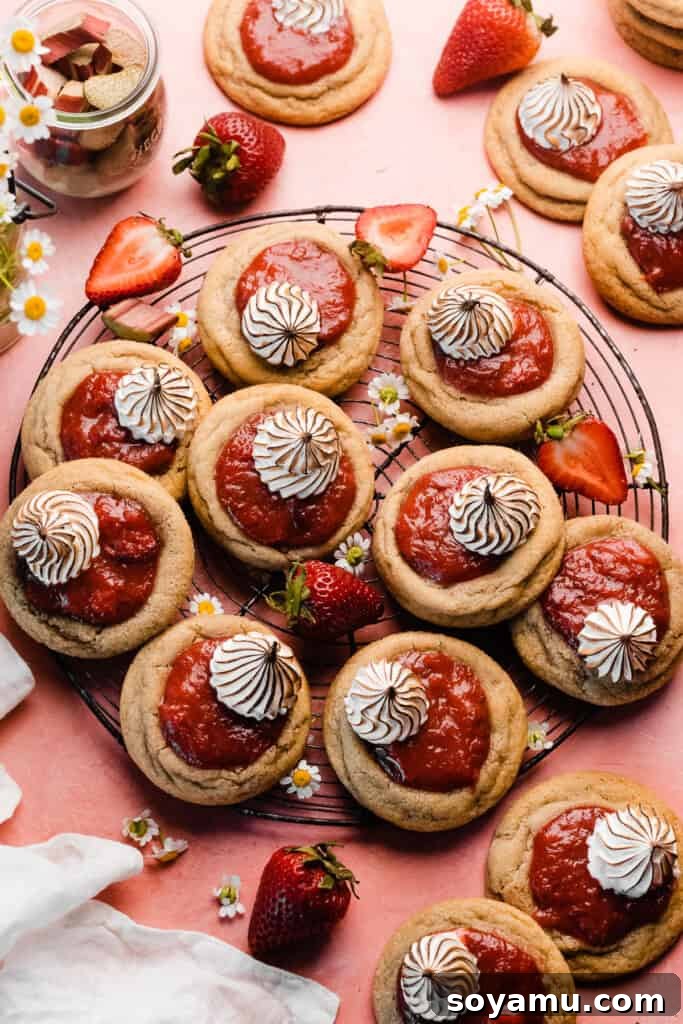 A charming bird's eye view of the strawberry rhubarb cookies resting on a vintage wire rack, placed on a lovely pink surface.