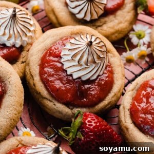 Strawberry Rhubarb Pie Cookies filled with vibrant pink fruit filling and topped with piped dollops of toasted meringue.