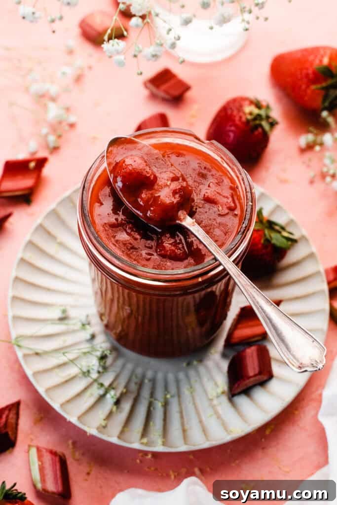 A jar of the rich, vibrant strawberry rhubarb sauce, or compote, ready to be used.