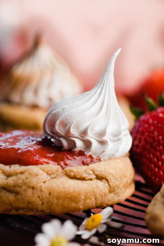 Crafting Silky Smooth Swiss Meringue 3 A close-up shot of a strawberry rhubarb pie cookie adorned with beautifully piped Swiss meringue.