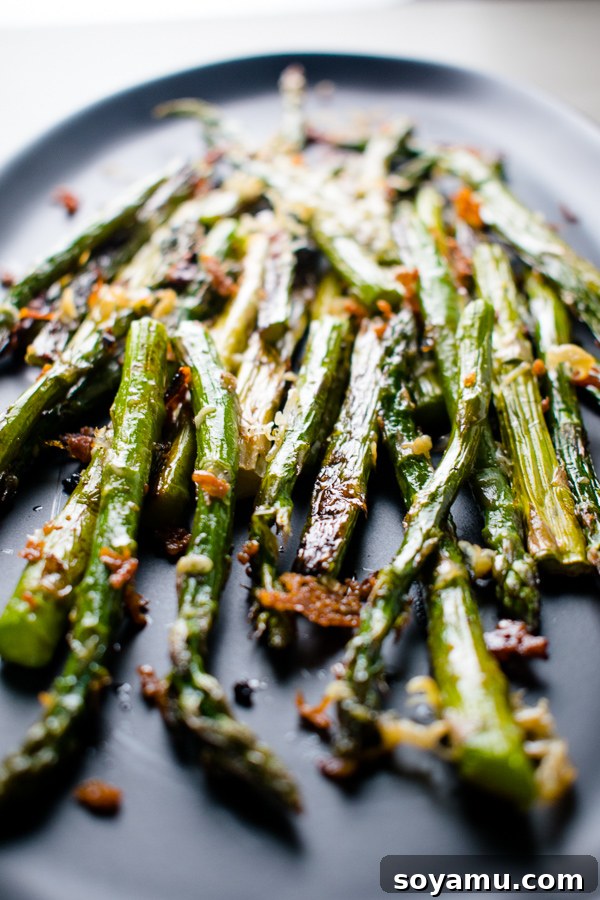 Golden Roasted Parmesan Asparagus 5 Parmesan Roasted Asparagus, garnished with fresh herbs and extra parmesan, ready to serve