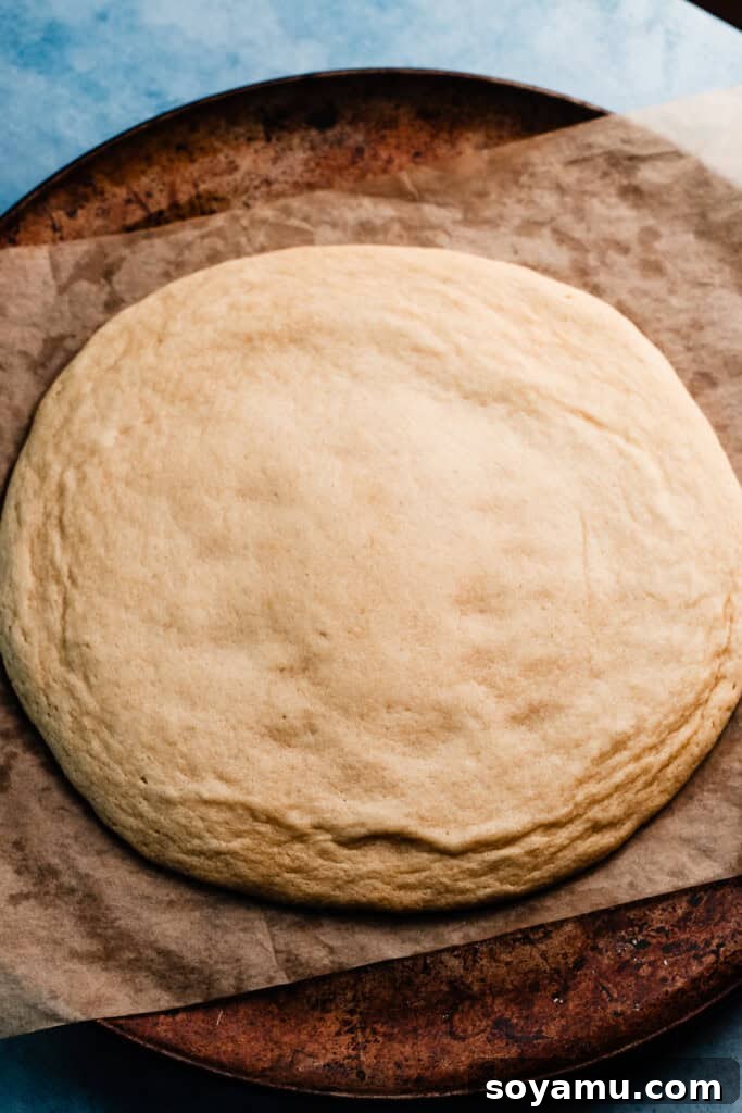 The baked sugar cookie crust, perfectly golden around the edges and set in the center, cooling on its baking pan, ready to be transformed into a delicious fruit pizza.