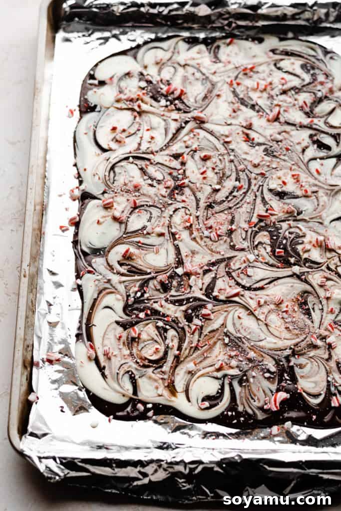 Easy Five-Ingredient Homemade Chocolate Bark 5 Swirled dark and white chocolate spread evenly on a lined cookie sheet, forming a beautiful base for the bark.