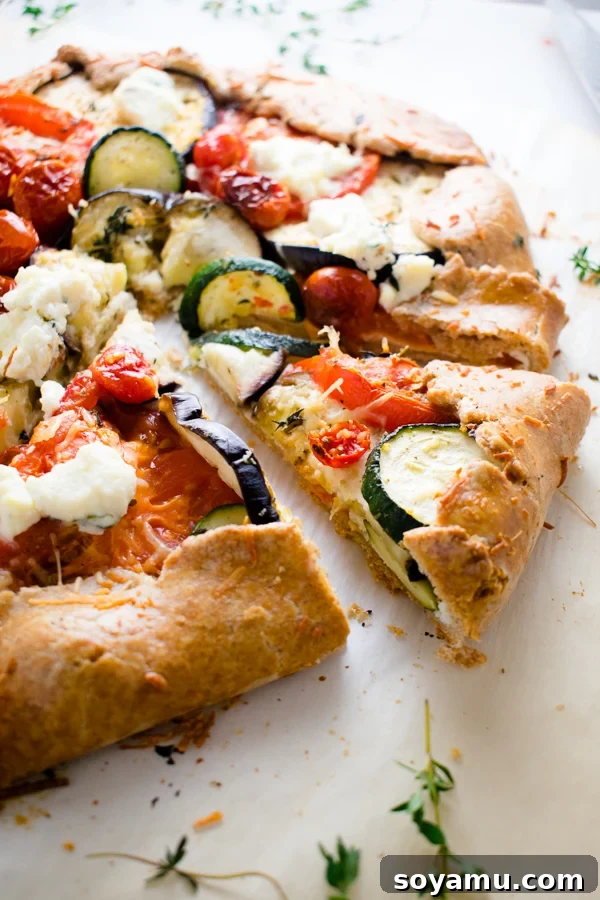 Close-up of a slice of Mixed Vegetable Galette, revealing layers of fresh vegetables and creamy ricotta cheese.
