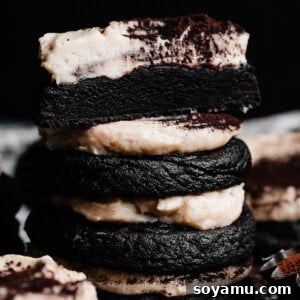 A stack of tiramisu cookies frosted in whipped mascarpone frosting and dusted with cocoa.