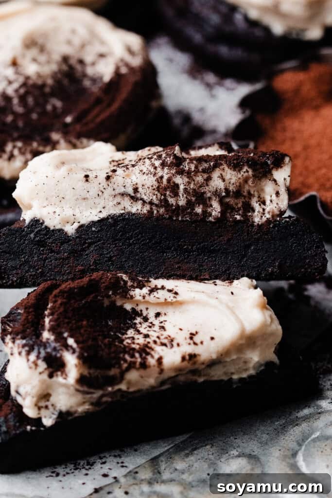 Tiramisu Cloud-Topped Cookies 9 A close-up shot of two halves of a tiramisu cookie, revealing its fudgy, espresso-infused interior and fluffy mascarpone frosting.