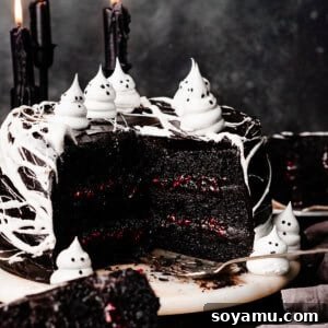 The beautifully sliced open black velvet cake on an elegant marble cake stand, revealing perfect layers of dark chocolate cake, creamy frosting, and vibrant raspberry filling.