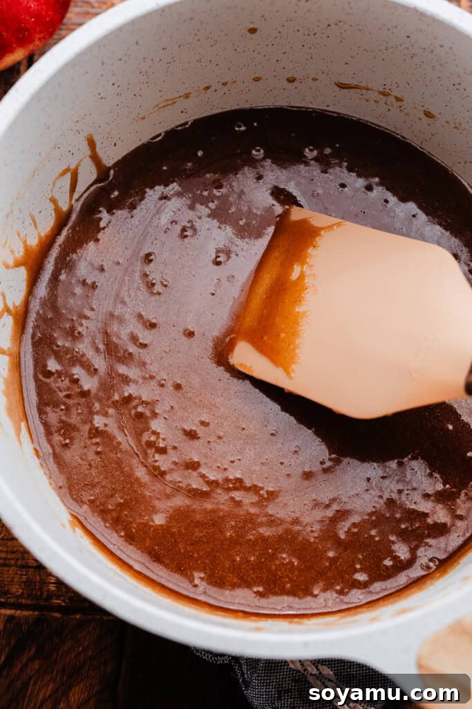 Sticky Apple Caramel Cake 4 A saucepan filled with rich, bubbling caramel sauce, ready for the apple upside down cake.
