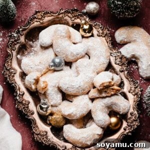 Sweet Almond Moons 11 A vintage tray full of beautifully golden and powdered sugar-dusted almond crescent cookies, ready for serving.