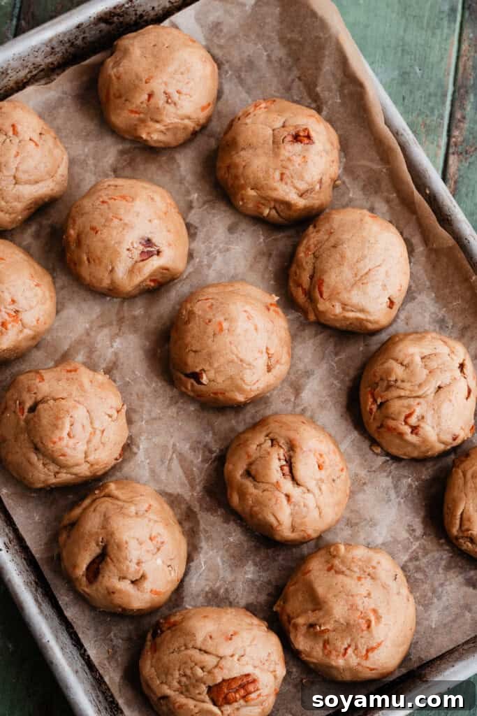 Spiced Carrot Cake Cookies with Brown Butter Cream Cheese 6 Several neatly rolled cookie dough balls chilling on a parchment-lined baking sheet.