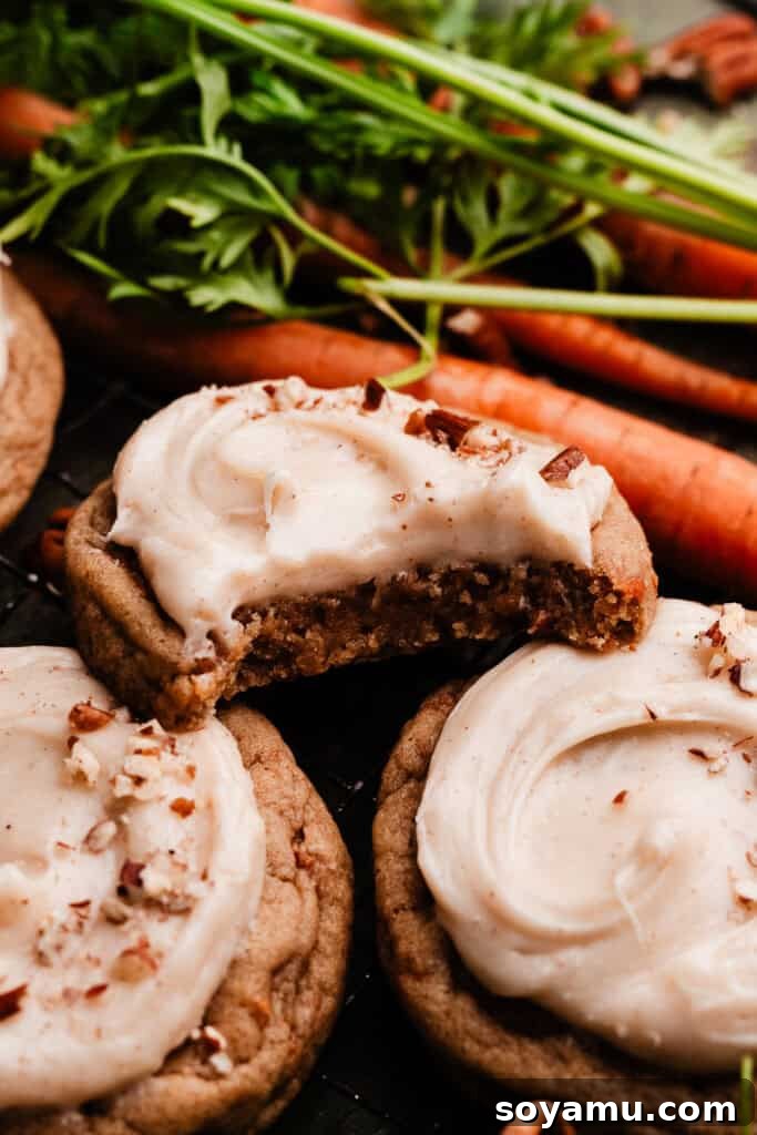 Spiced Carrot Cake Cookies with Brown Butter Cream Cheese 10 A frosted carrot cake cookie with a bite taken out of it, revealing its soft interior.