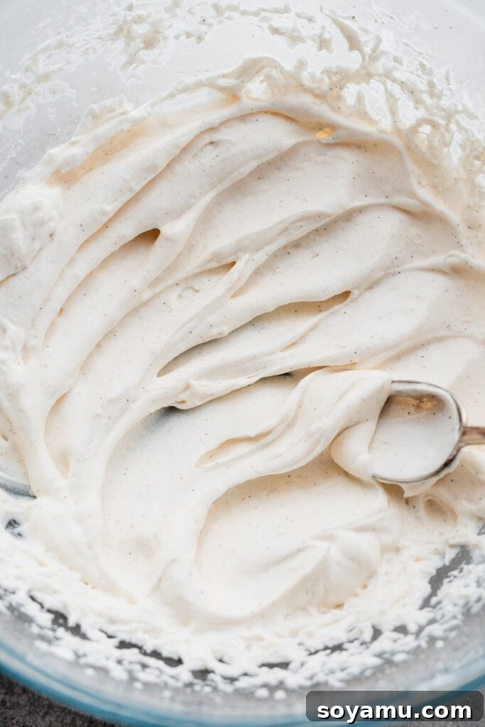 Whip Up Perfect Homemade Cream 9 A spoon creating soft waves in a bowl of freshly made whipped cream.