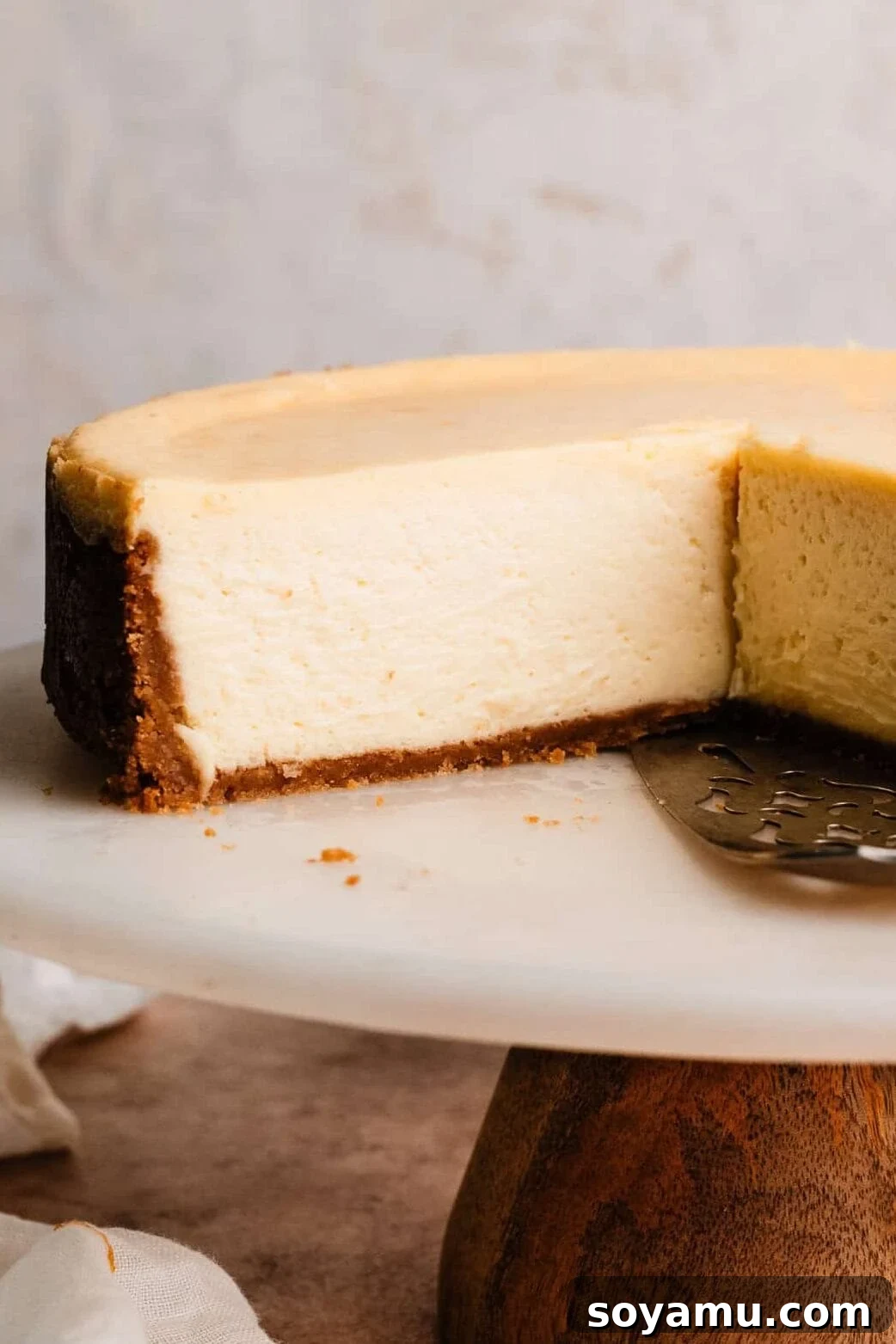 Velvety Rich New York Cheesecake Masterpiece 2 A close-up of a plain, sliced New York Style Cheesecake, showcasing its incredibly creamy and dense texture.