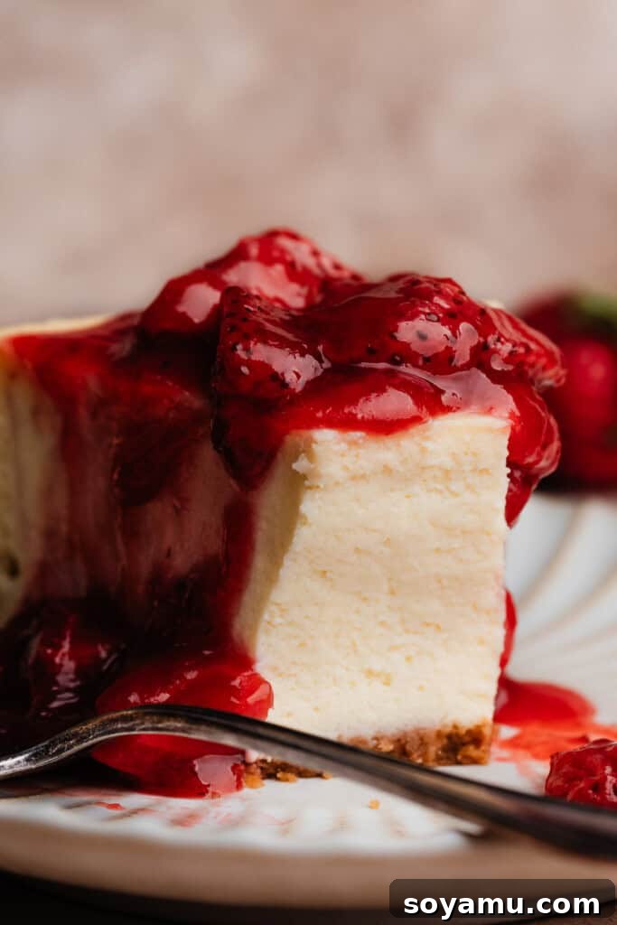 Velvety Rich New York Cheesecake Masterpiece 15 A close-up shot of a single slice of New York Style Cheesecake with a bite taken out, perfectly showcasing its dense, incredibly creamy, and rich interior texture.