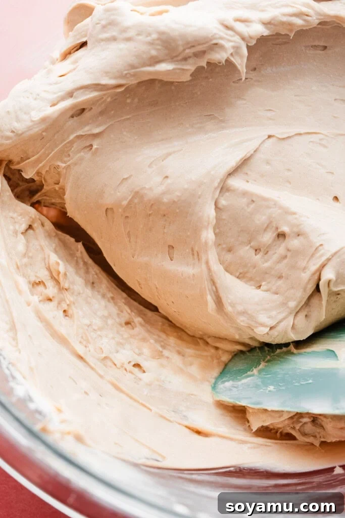 Velvety Rich New York Cheesecake Masterpiece 8 A close-up view of the bottom of a mixing bowl, revealing hidden lumps of cream cheese that were not fully incorporated into the batter.
