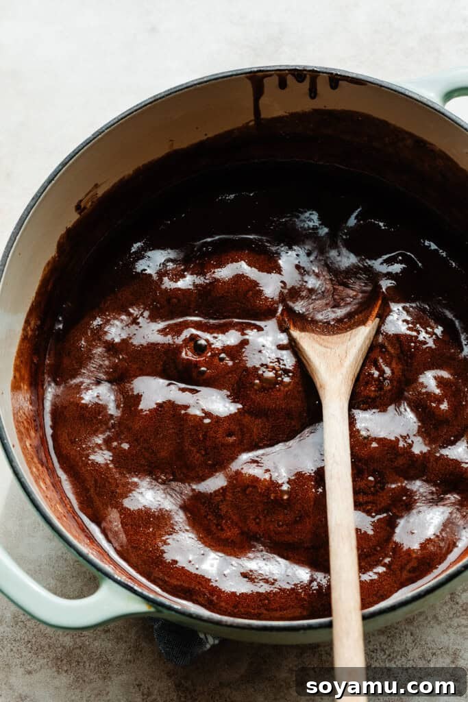Easy No Bake Peanut Butter Chocolate Treats 4 A pot of the chocolate mixture being heated on the stove, showing its smooth, glossy texture.